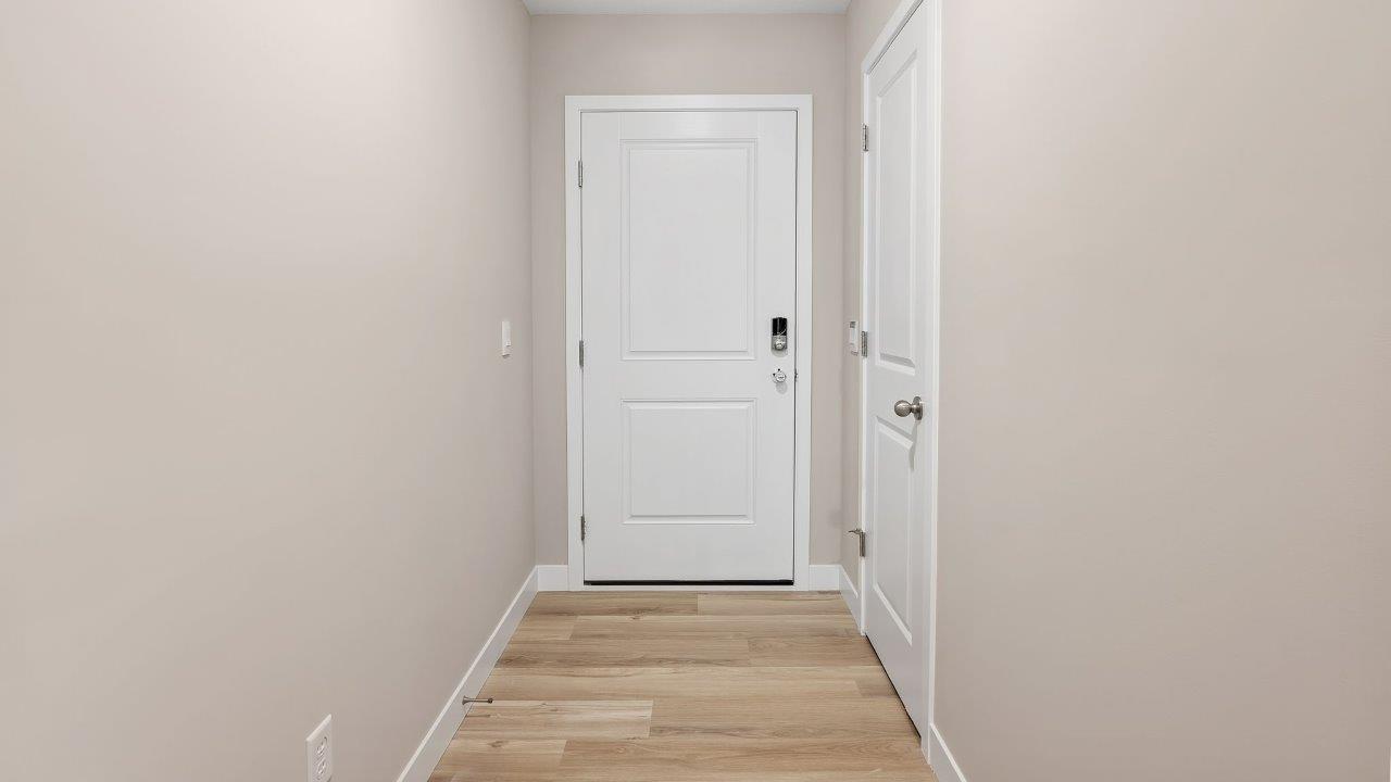 fawn creek estates freeport - front door and foyer with lvp flooring leading into open layout living room