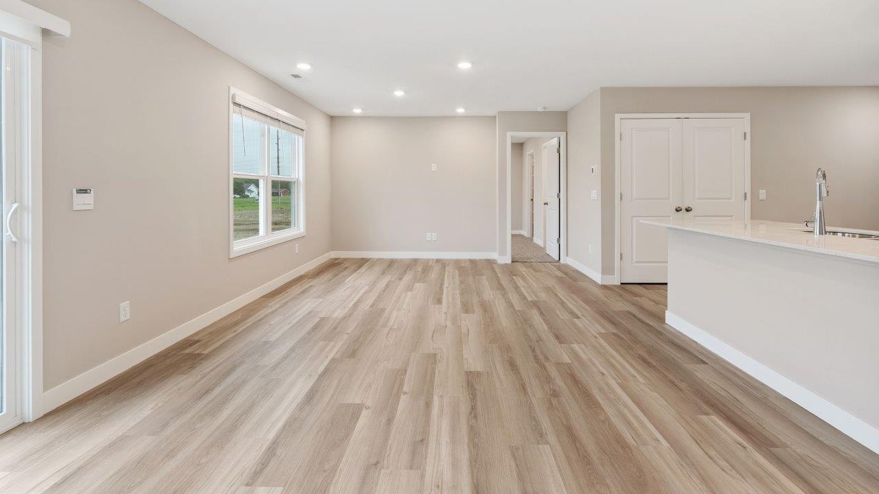 fawn creek estates freeport - open layout living room with mohawk lvp flooring, 2 windows, and open to kitchen and dining room
