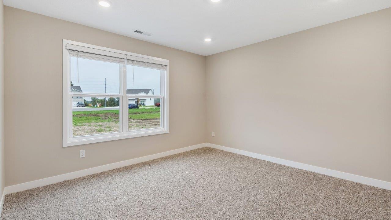 fawn creek estates freeport - primary bedroom with carpet flooring, 2 windows, and ensuite bathroom and walk in closet