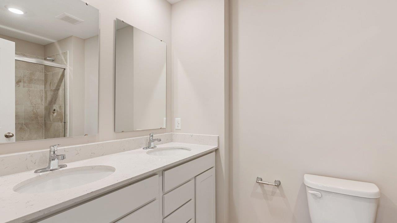 fawn creek estates freeport - primary bedroom ensuite bathroom with dual sink vanity and tile walk in shower