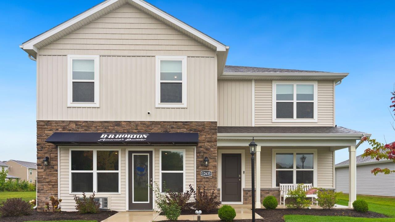 farmstead at carroll creek henley model home exterior with covered front porch, sodded yard, and landscaping