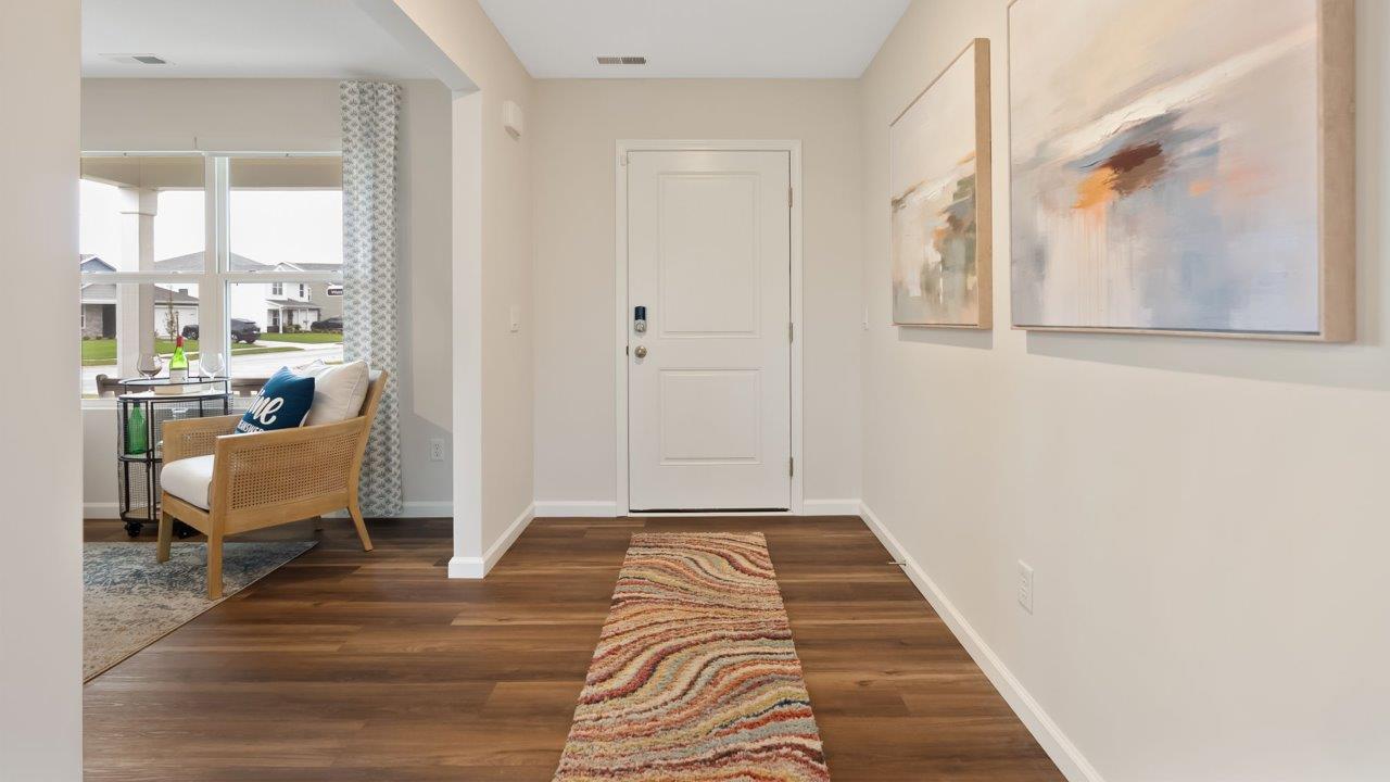 farmstead at carroll creek henley model home interior front door and foyer with mohawk eastmont lvp flooring leading into study and living room