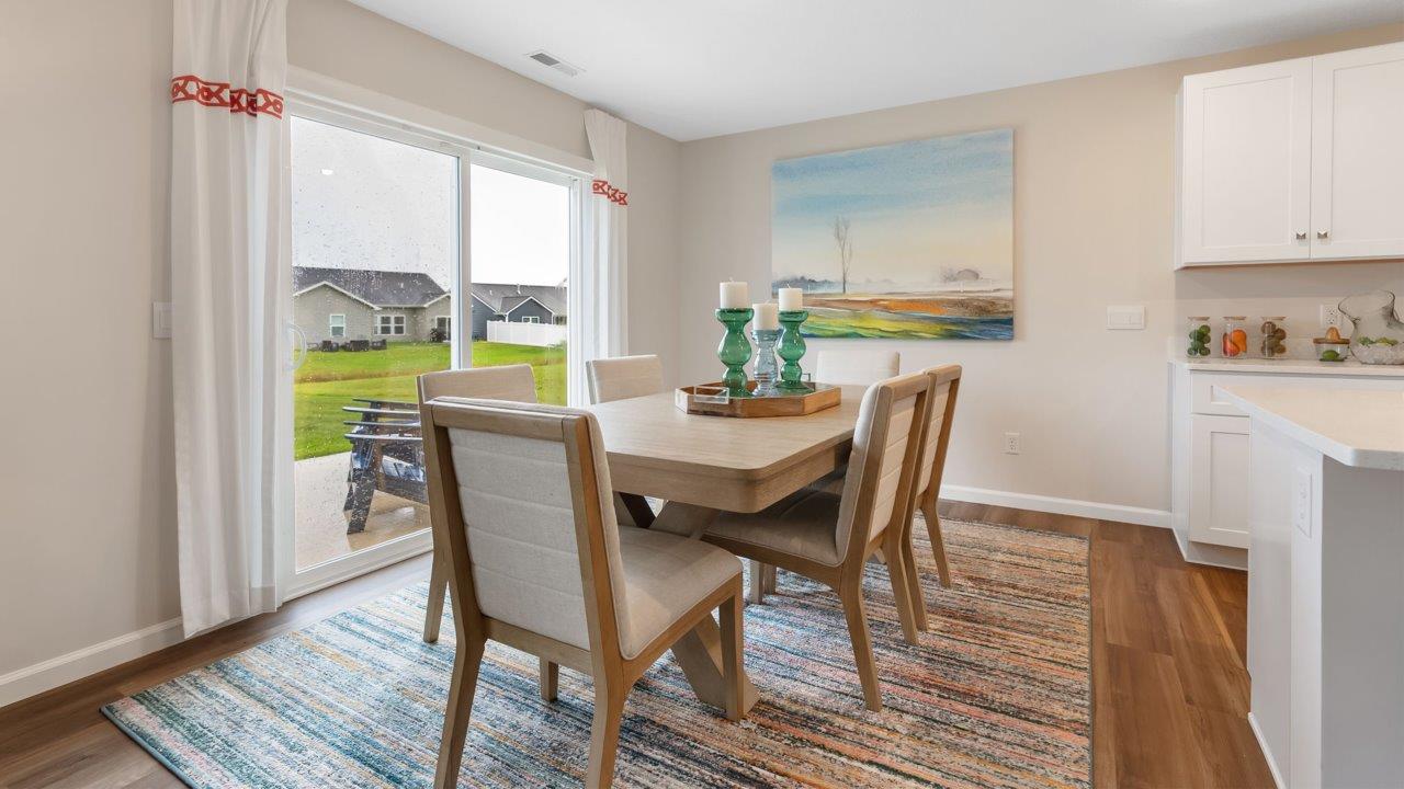 farmstead at carroll creek henley model home casual dining room with lvp flooring and sliding glass door leading to backyard and patio