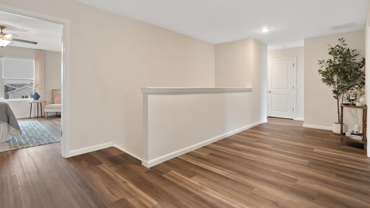 farmstead at carroll creek henley model home second floor stair landing and spacious hallway with lvp flooring