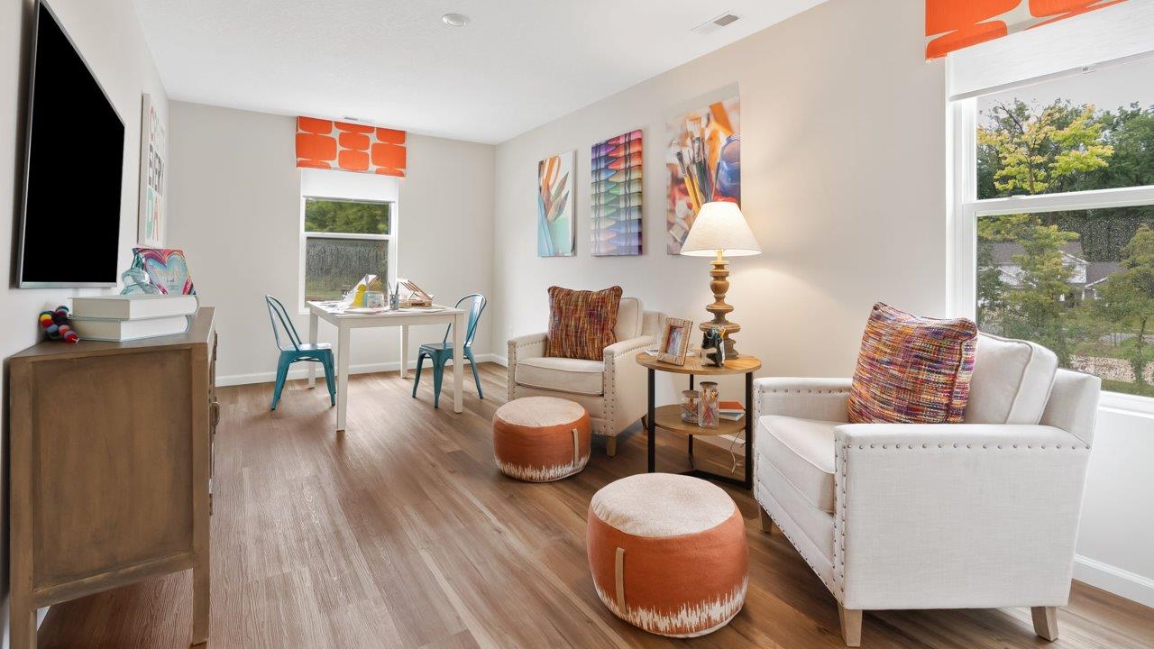 farmstead at carroll creek henley model home second floor loft with mohawk eastmont lvp flooring, 2 windows, and furnished as kids hobby and tv room