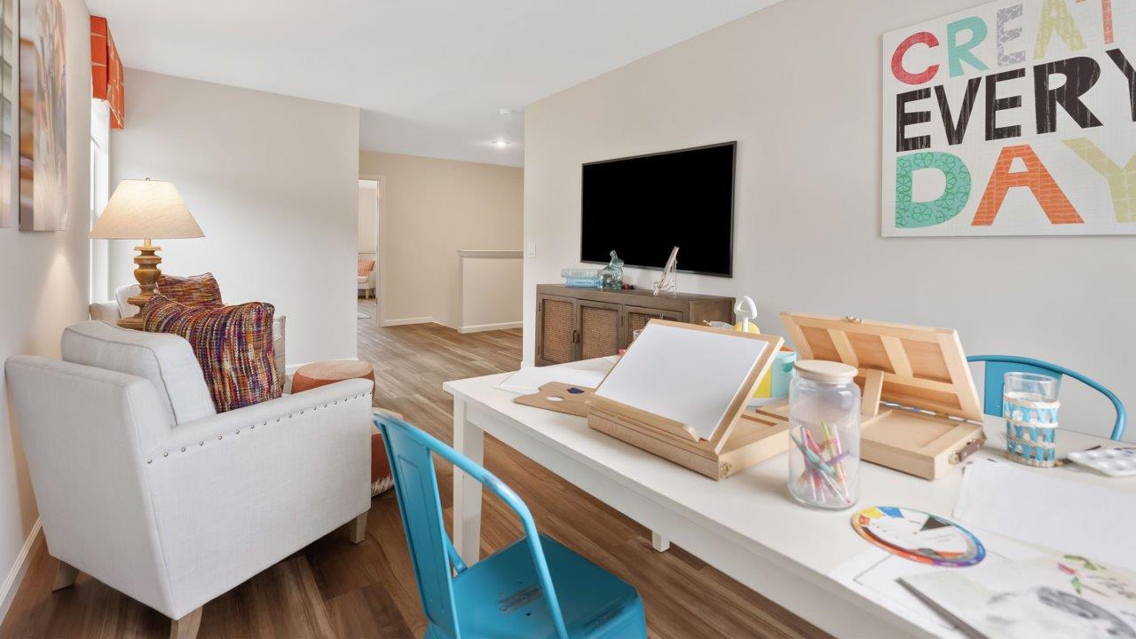 farmstead at carroll creek henley model home second floor loft with mohawk eastmont lvp flooring, 2 windows, and furnished as kids hobby and tv room
