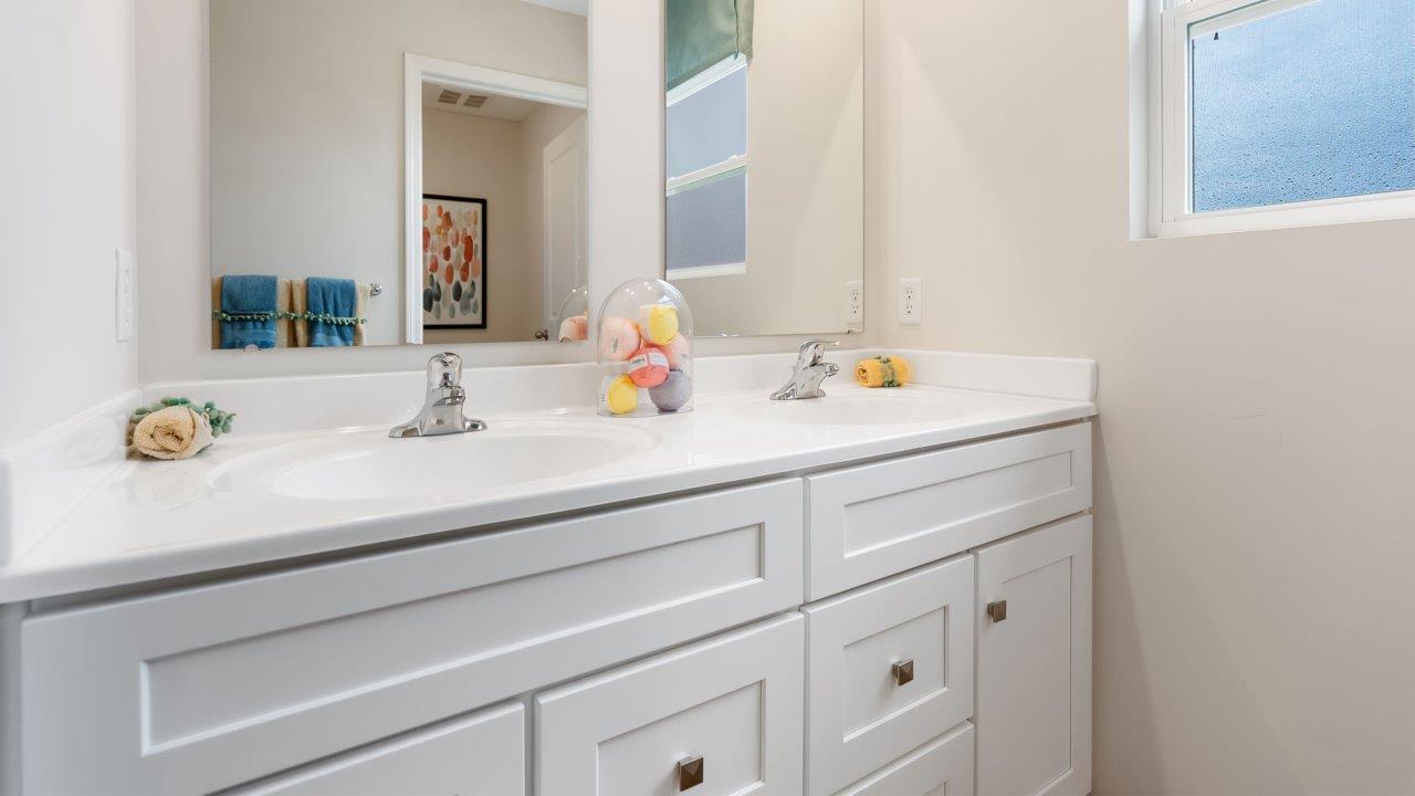 farmstead at carroll creek henley model home full bathroom with dual sink vanity, tub shower, and private water room