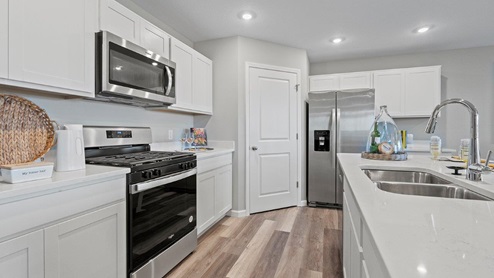 Sonora Chatham Model home kitchen with Moen chrome pull down faucet