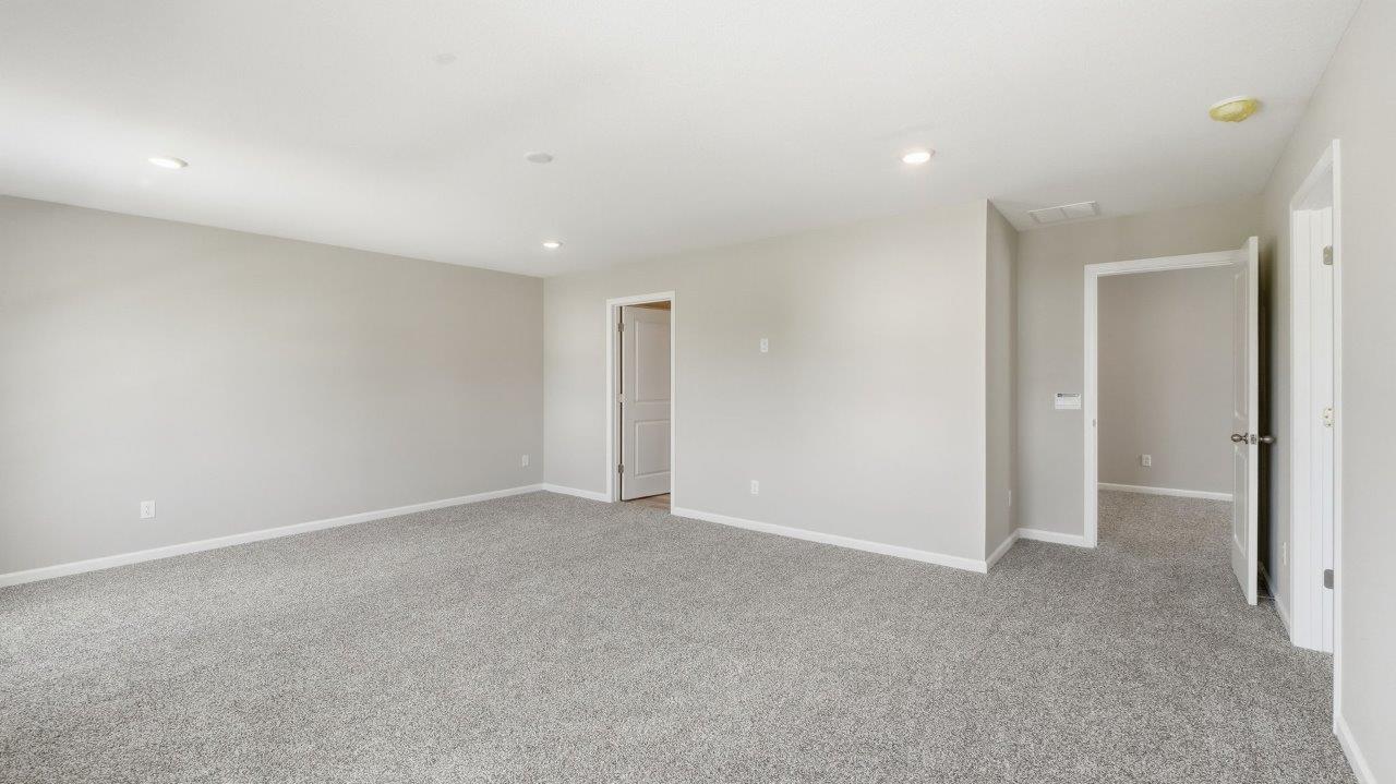 sonora elm primary bedroom with carpet flooring popular grey walls and ensuite full bathroom and walk in closet