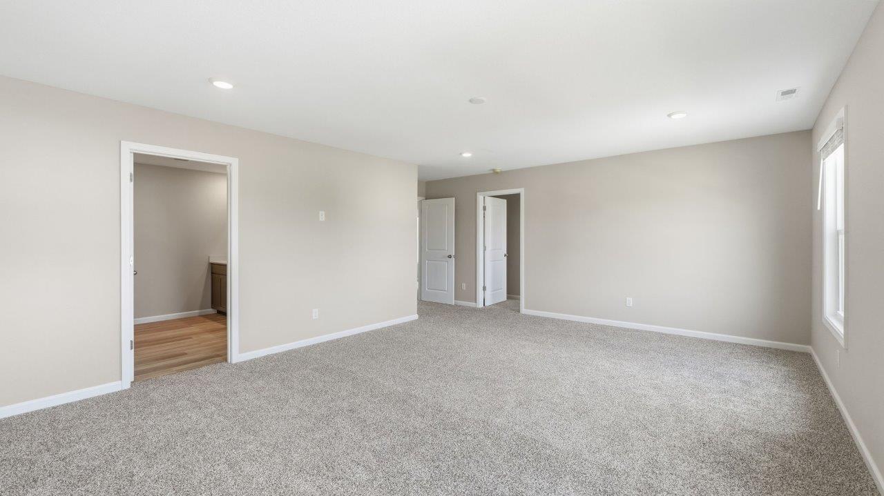 sonora elm primary bedroom with carpet flooring popular grey walls and ensuite full bathroom and walk in closet