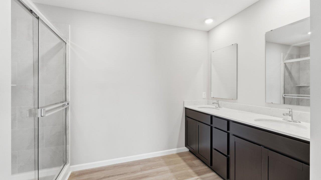 sonora elm primary ensuite bathroom with dual sink vanity and walk in ceramic tile shower with lvp flooring