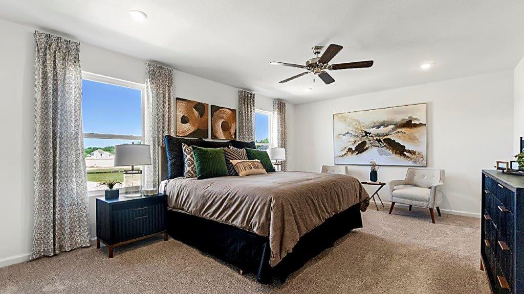 bellamy primary bedroom wtih carpet flooring, open space, fan, and natural light