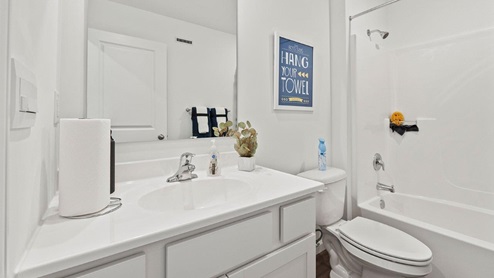 Chatham model bath 2 with single sink with cultured white marble countertops and a tub shower.