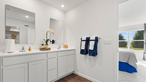 Chatham model bathroom off of main bedroom with dual vanity sinks and white marble countertops