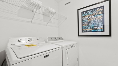 Chatham model laundry room with hookups and wire shelving for storage
