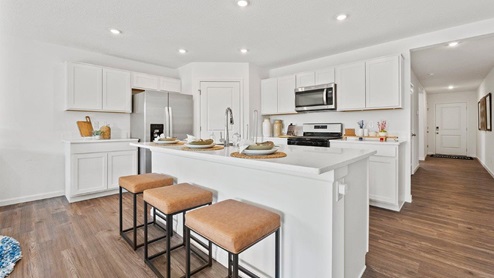 Chatham Model Home Kitchen with white cabinetry and large island with room for seating