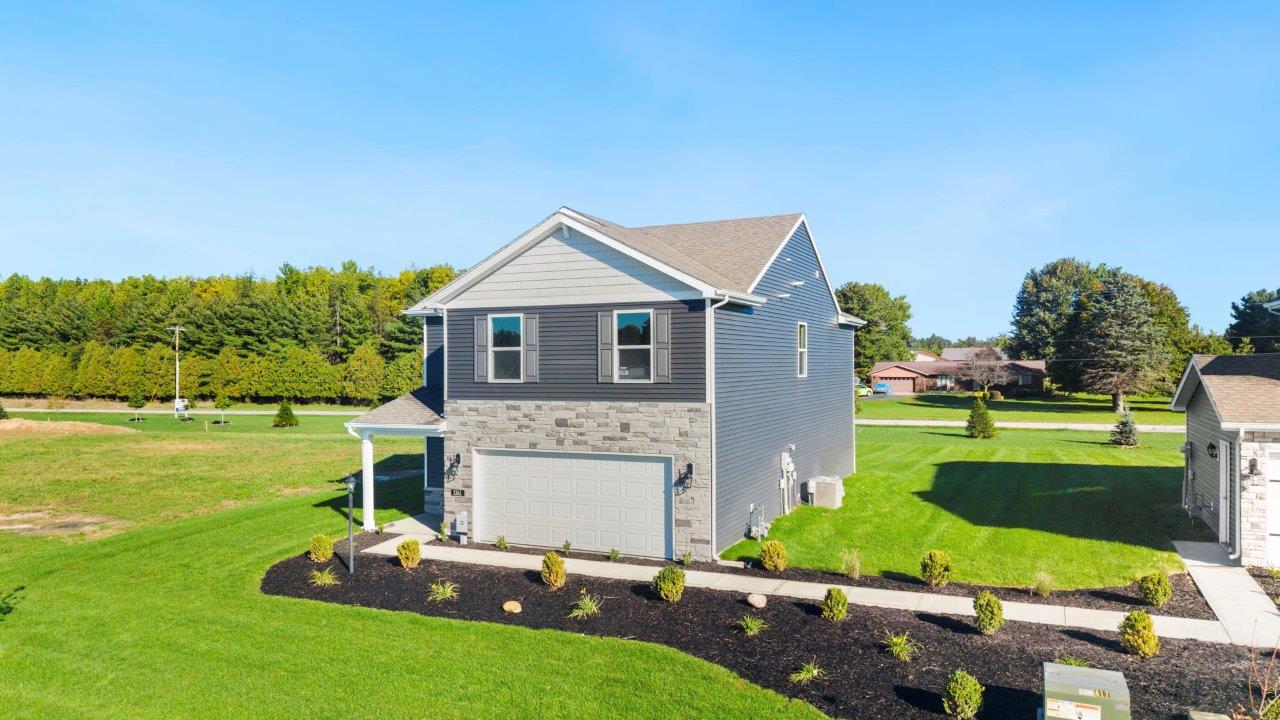 Greenbrier Pine Model Home - exterior with ironstone  vinyl siding, tuesdeo grey shutters, sterling shake, and weathered edge manistee stone