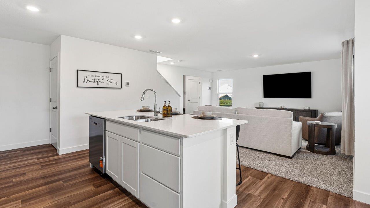 Greenbrier Pine Model Home - kitchen with white cabinets, quartz countertops, center island, pantry, and stainless steel appliances