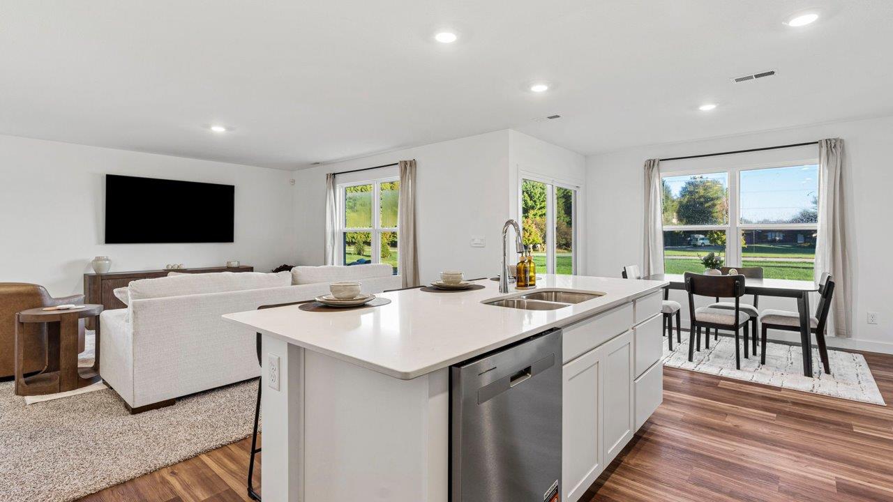 Greenbrier Pine Model Home - kitchen with white cabinets, quartz countertops, center island, pantry, and stainless steel appliances