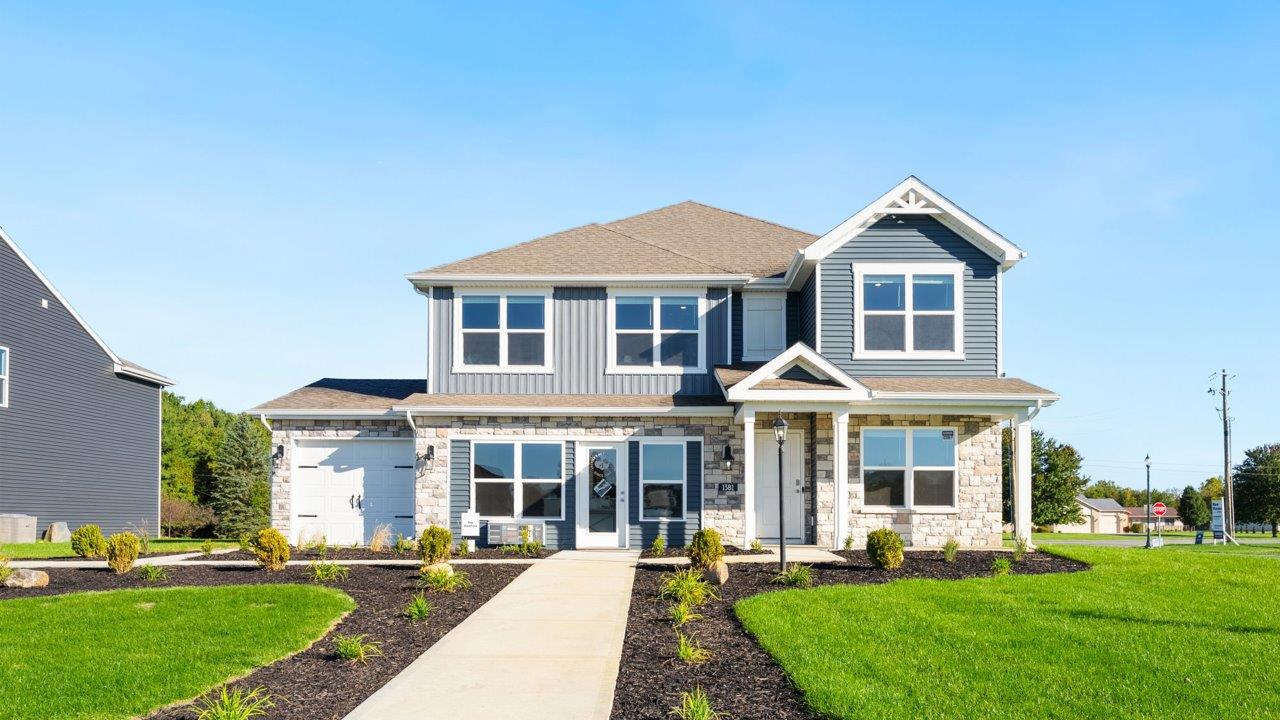 Greenbrier Stamford Model Home - exterior with midnight surf vinyl siding, storm board and batton, white shutters, and cobblestone sandy beige stone