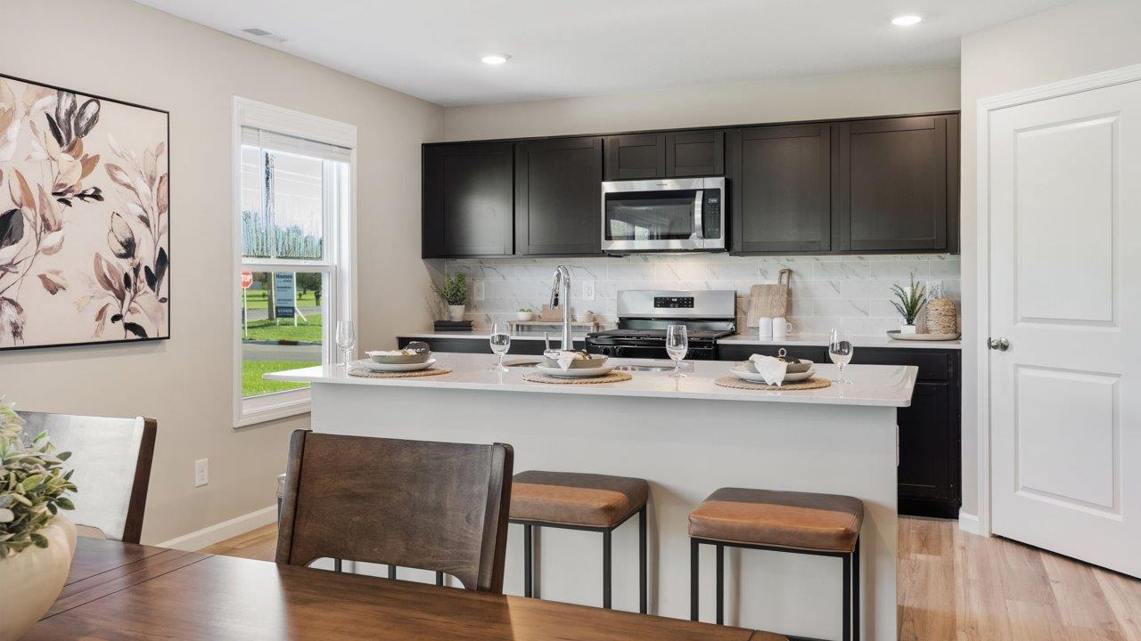 Greenbrier Stamford Model Home - sarsaparilla cabinets, lyra quartz countertops, stainless steel appliances, center island, and corner pantry