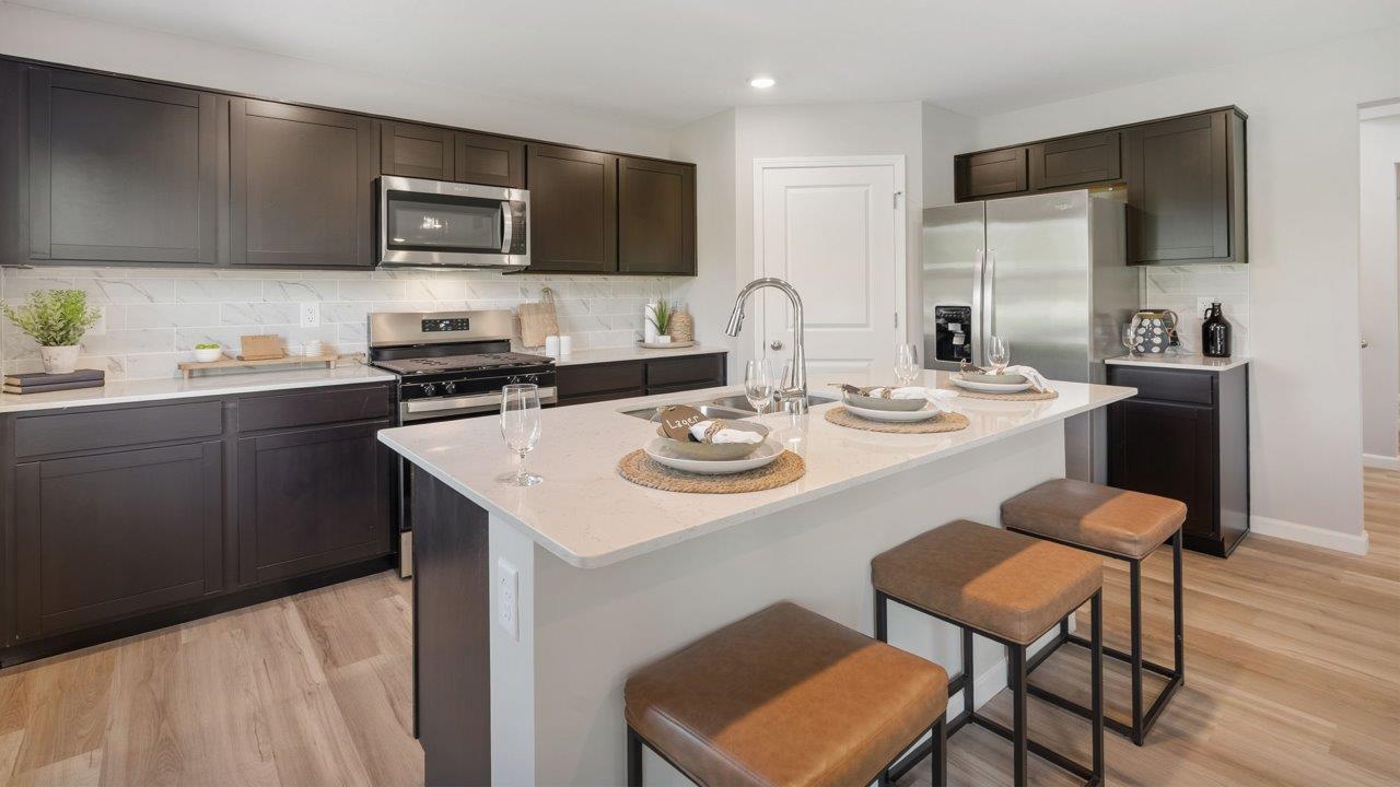 Greenbrier Stamford Model Home - sarsaparilla cabinets, lyra quartz countertops, stainless steel appliances, center island, and corner pantry