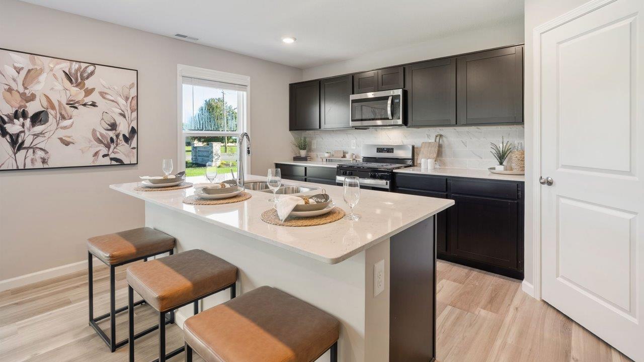Greenbrier Stamford Model Home - sarsaparilla cabinets, lyra quartz countertops, stainless steel appliances, center island, and corner pantry