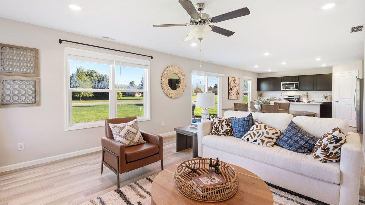 Greenbrier Stamford Model Home - living room with ceiling fan, mohawk avery lvp flooring, large windows, and popular grey windows