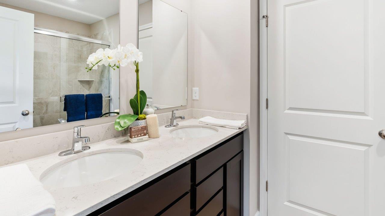 Greenbrier Stamford Model Home - primary bedroom ensuite bathromo with dual sink vanity, quartz countertops, walk in tile shower