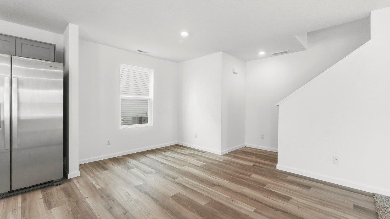 dining with lvp flooring and staircase