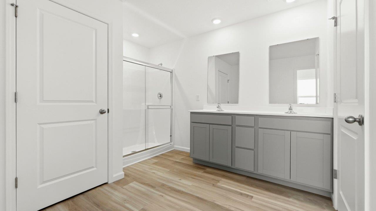 primary ensuite bath with dual sinks, walk in shower, and private water room