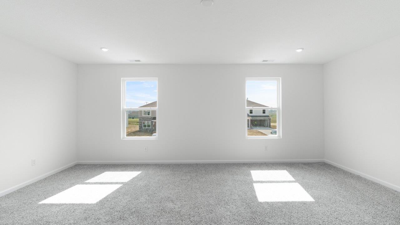 Elm primary bedroom with ensuite walk-in closet and bath with carpet flooring and 2 windows