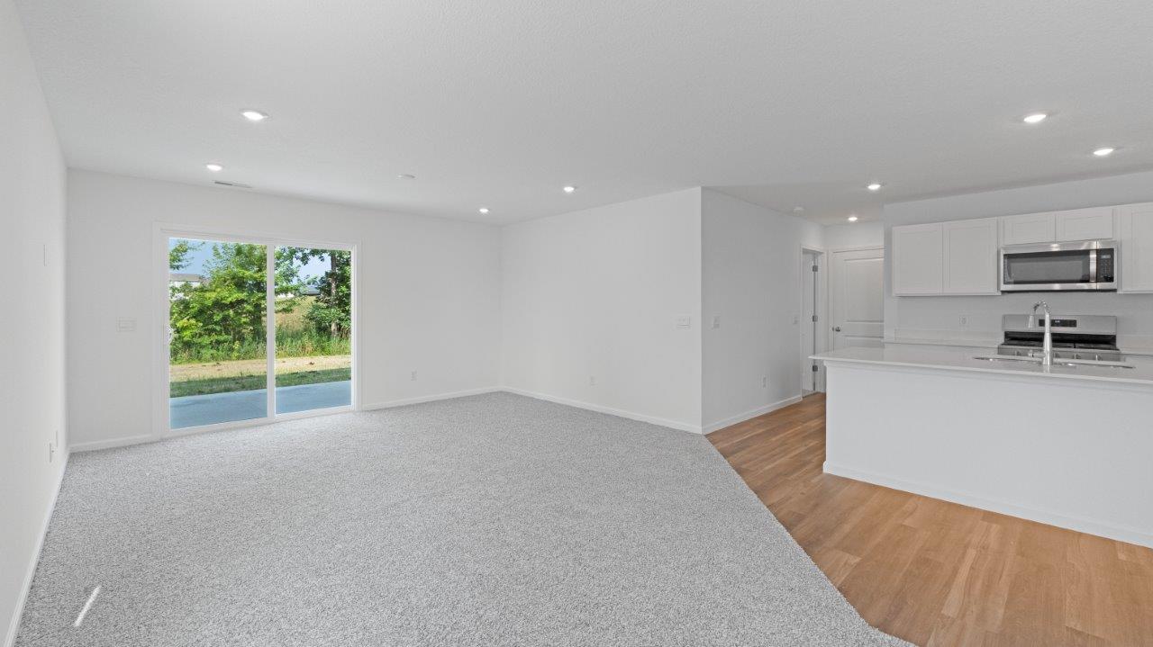 Elm living room with carpet flooring and sliding glass door to backyard