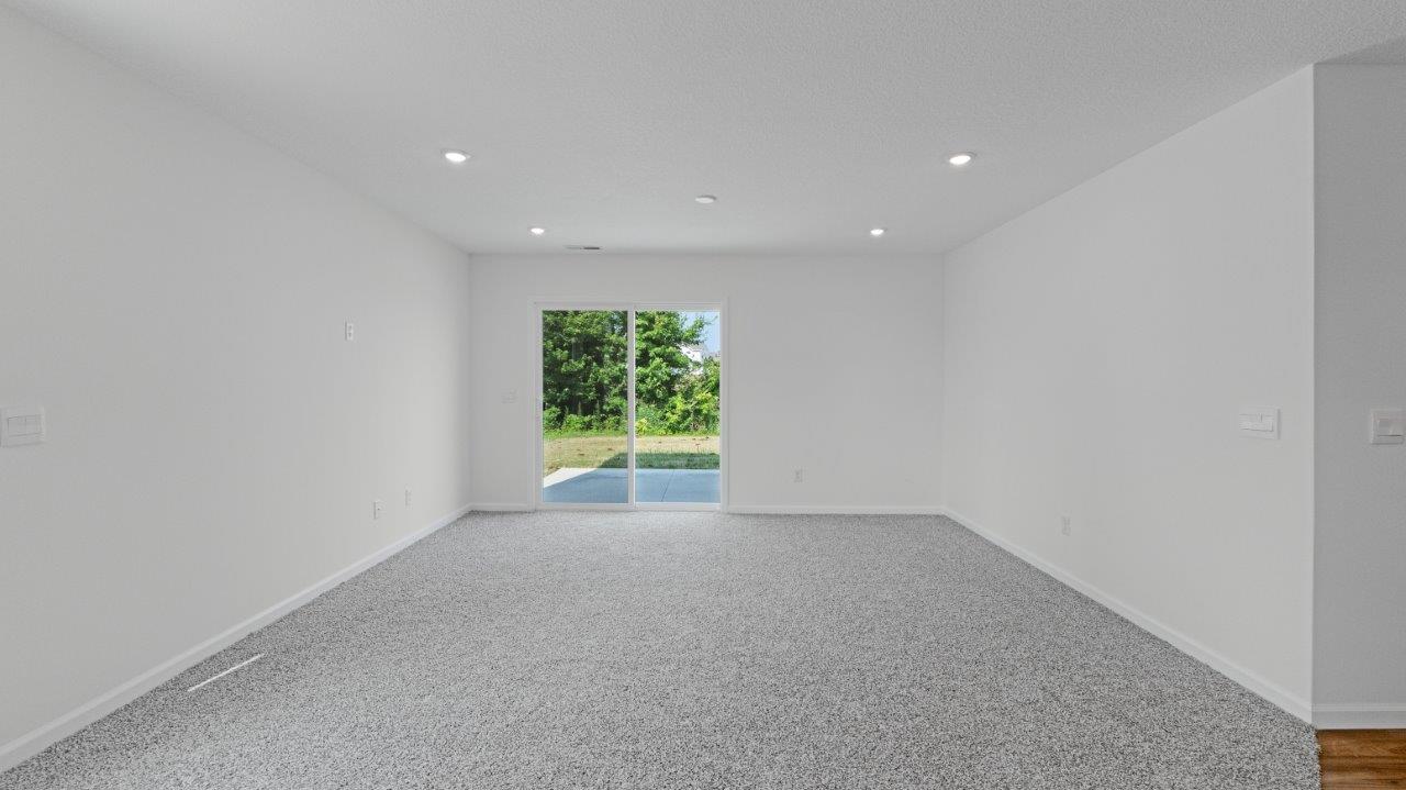 Elm living room with carpet flooring and sliding glass door to backyard
