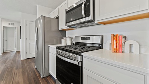 Riverwalk Aldridge Model Home - Kitchen with white cabinetry and white quartz countertops.