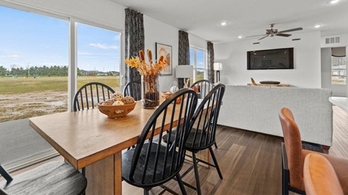 Riverwalk Aldridge Model Home - dining room next to sliding glass door to backyard and LVP flooring.