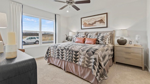 Riverwalk Aldridge model home - main bedroom with 52" ceiling fan with 2 large windows for natural lighting.