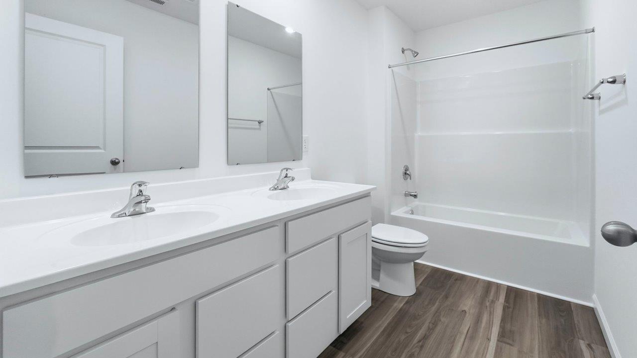 full bathroom with tub shower and dual sinks