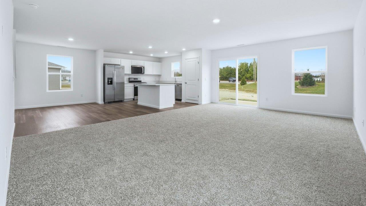 open layout living room and kitchen with carpet and lvp