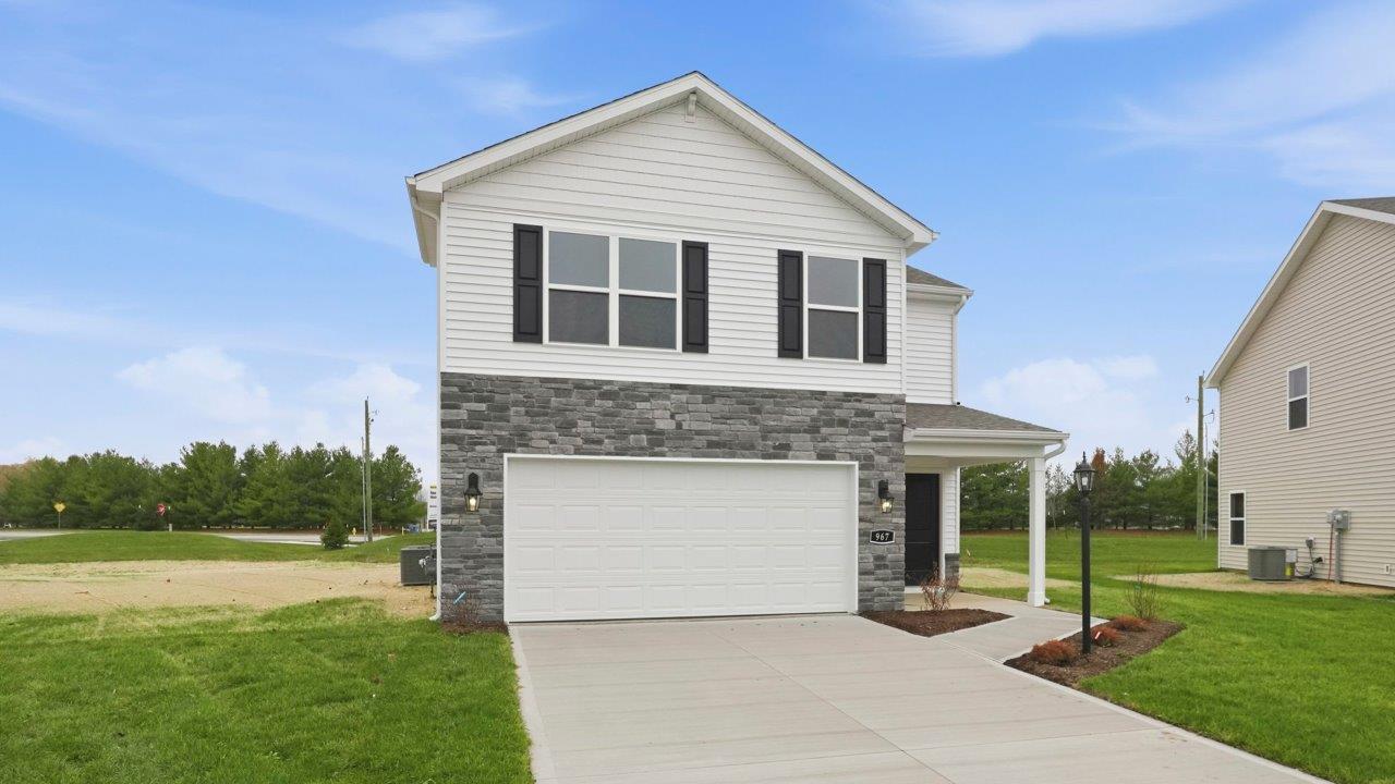 riverwalk elder 2 story home with front patio, sod, and landscaping