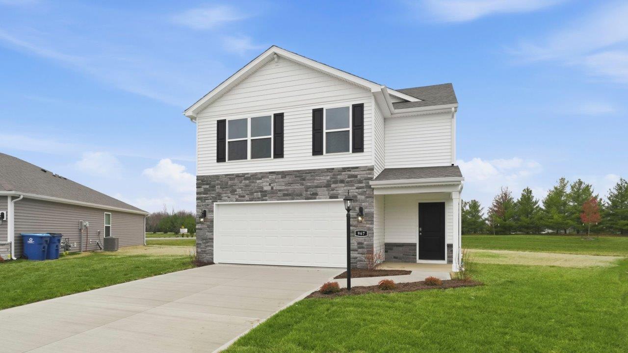 riverwalk elder 2 story home with front patio, sod, and landscaping