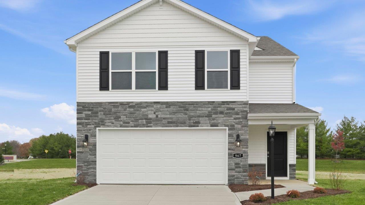 riverwalk elder 2 story home with front patio, sod, and landscaping