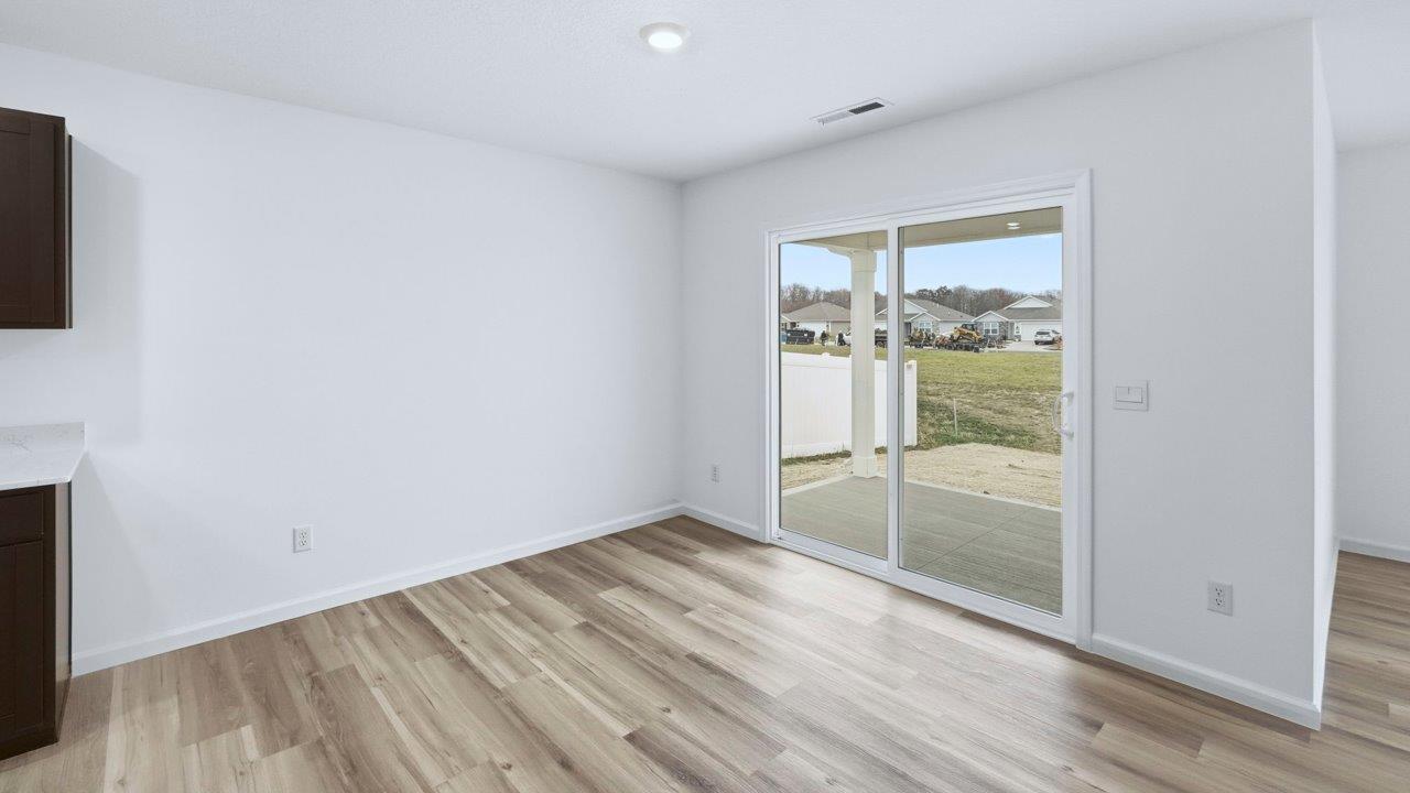 kitchen and dining open layout with lvp and sliding door to backyard covered patio