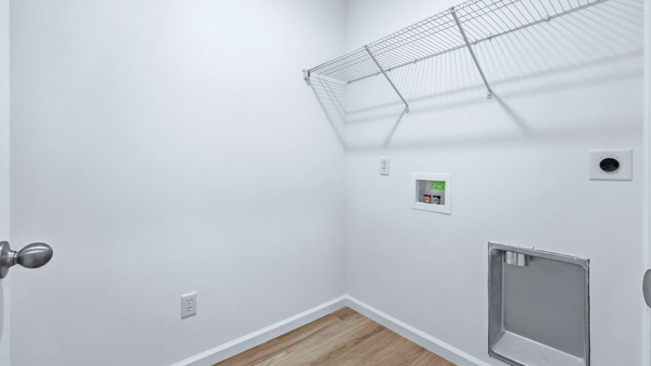 laundry room with lvp, hookups, and shelving