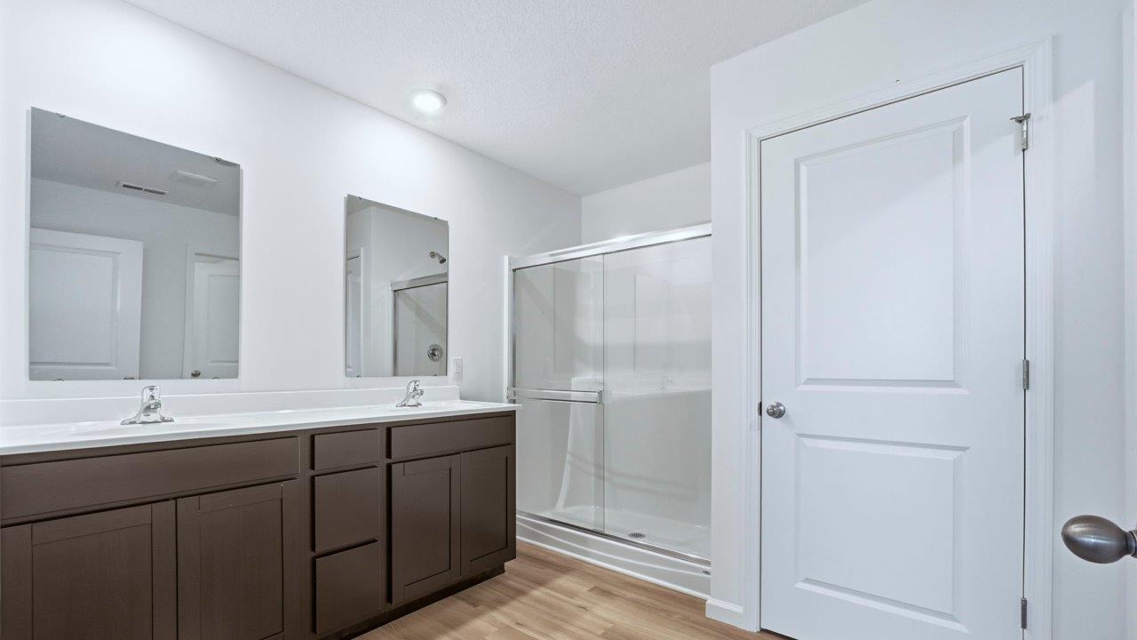 primary ensuite bathroom with dual sinks, walk in shower, and private water room