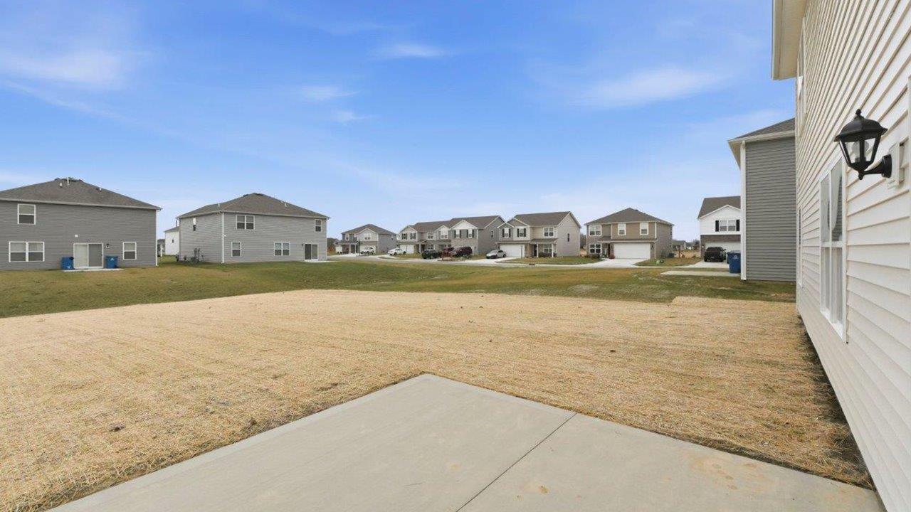 rear exterior with large backyard and concrete patio