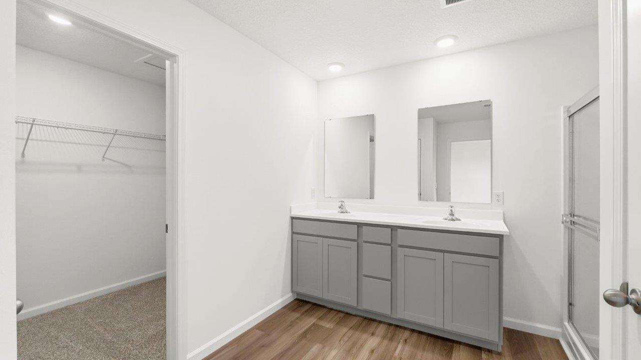 primary ensuite bath with dual sinks and walk in shower