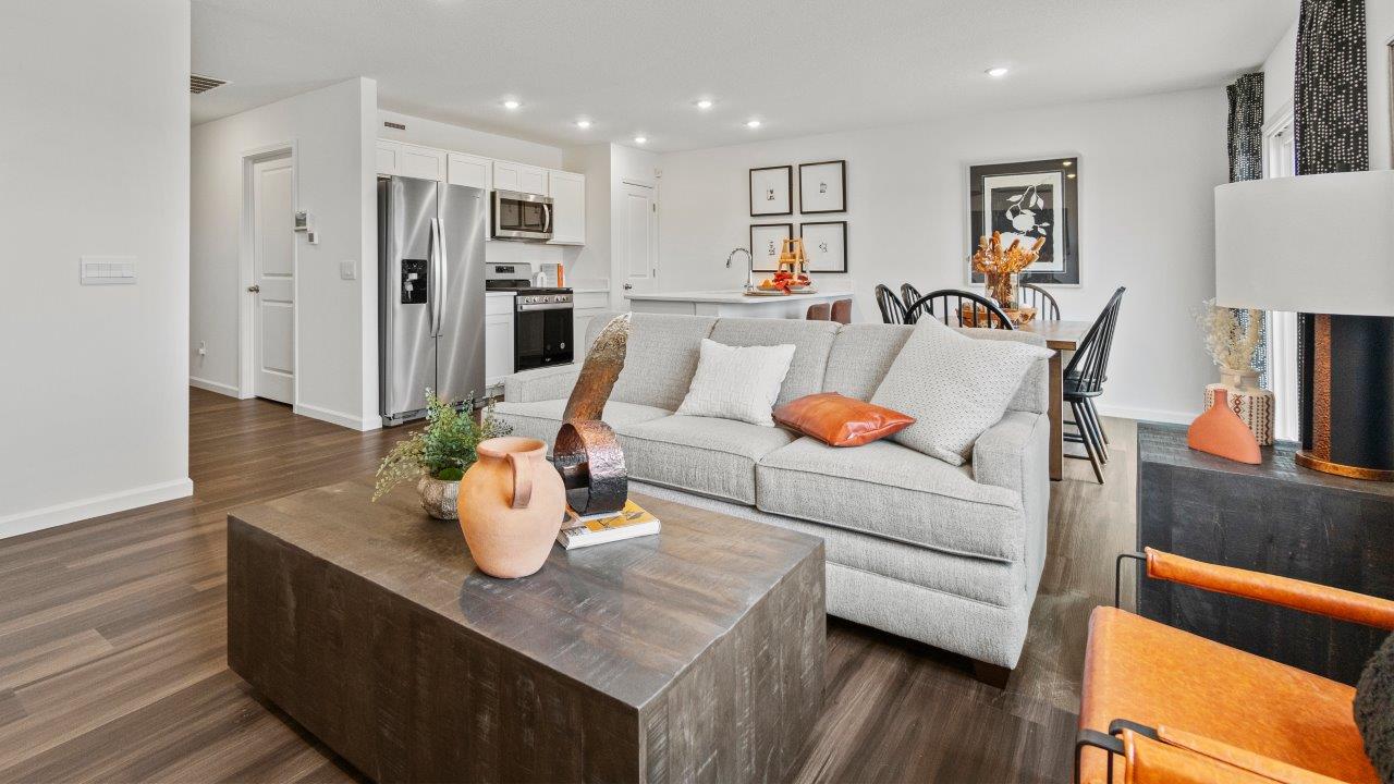 riverwalk aldridge model open layout living room with ryder lvp flooring, ceiling fan, 2 windows, and furnished