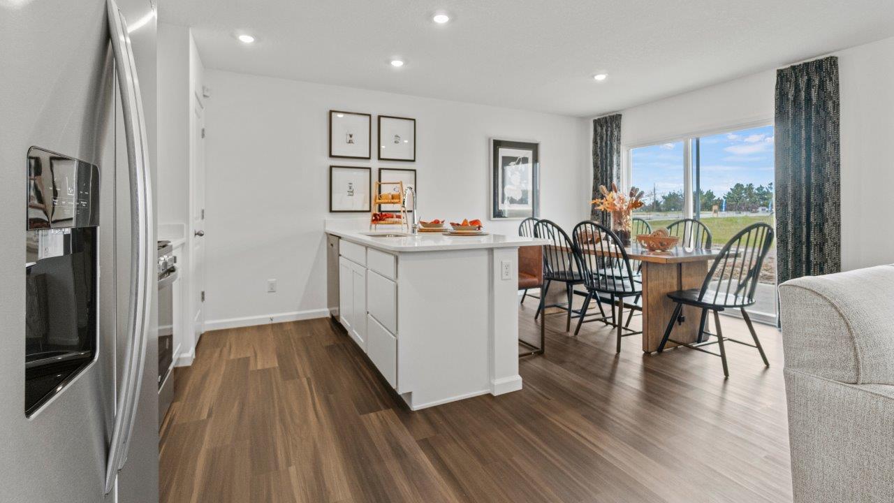 riverwalk aldridge model open layout living room with ryder lvp flooring, ceiling fan, 2 windows, and furnished