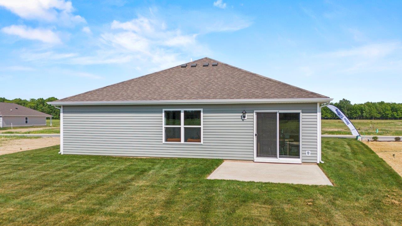 riverwalk aldridge model rear exterior with sodded backyard and concrete patio